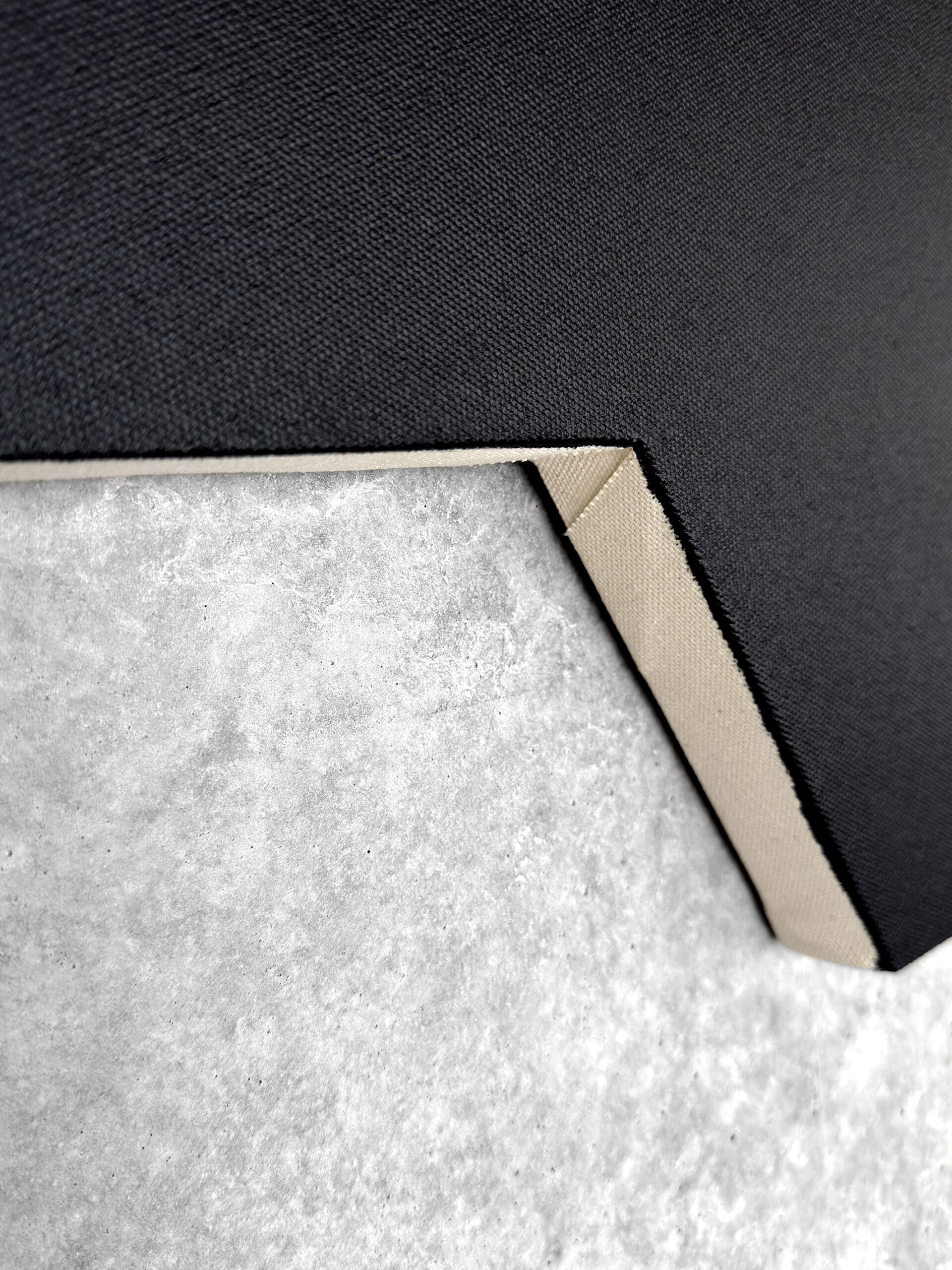 Macro detail of the raw inner edge and fine black canvas texture of Jean-Charles Kien's shaped artwork