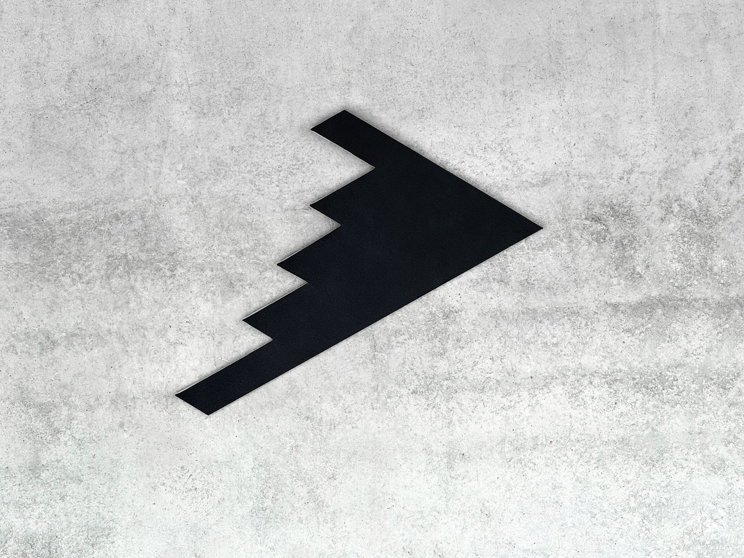 Black monochrome shaped canvas B2S2 by Jean-Charles Kien mounted on a raw concrete wall