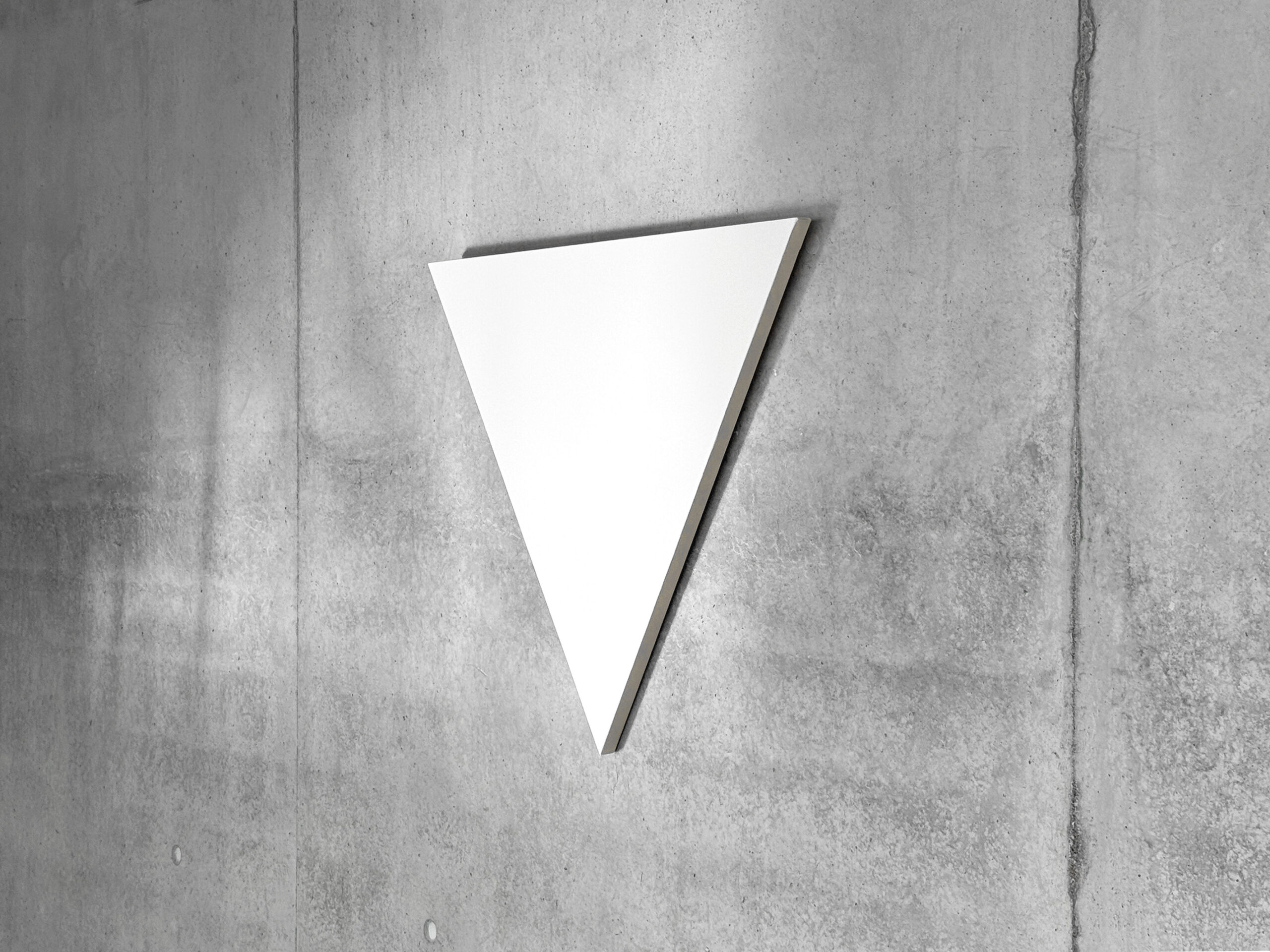 Side perspective view of Jean-Charles Kien's white inverted triangle painting mounted on a gray concrete wall