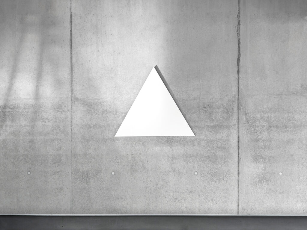White monochrome shaped canvas painting WTM2 by Jean-Charles Kien hanging centered on a raw concrete wall