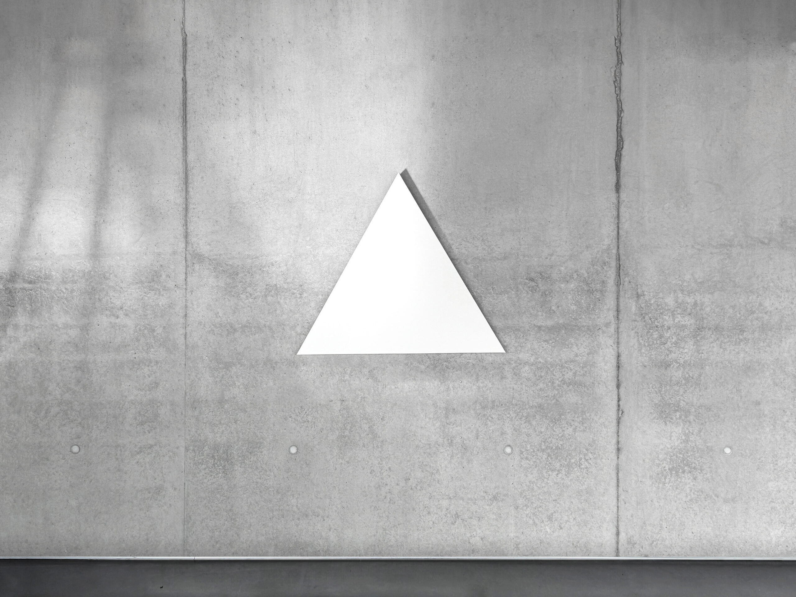 White monochrome shaped canvas painting WTM2 by Jean-Charles Kien hanging centered on a raw concrete wall